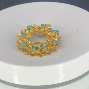 Gold colored with blue beads on leaves